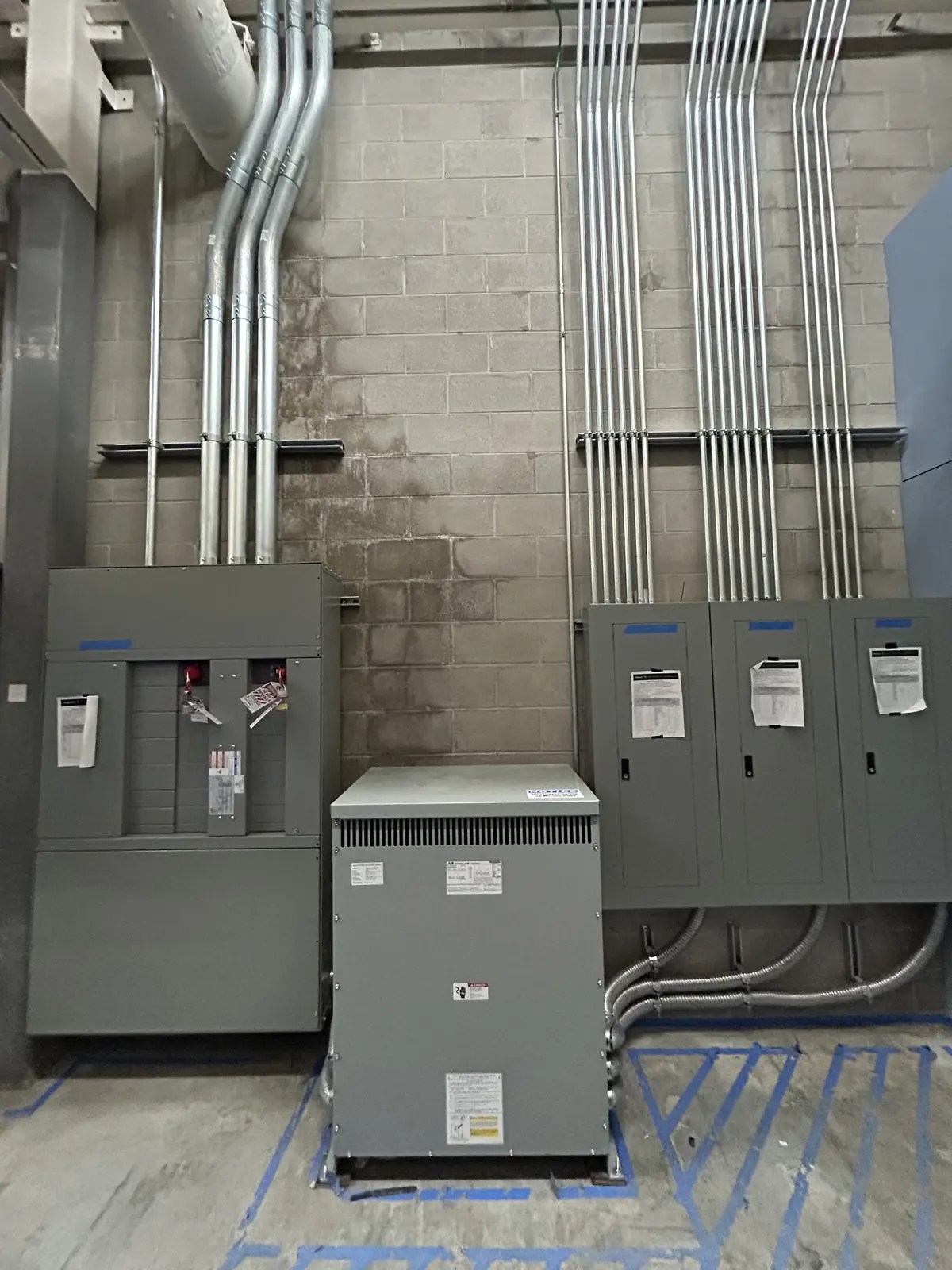 Service panels: New service panels and transformer installed on a block wall.